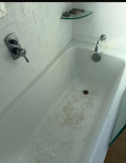 Before: Bathtub with soap scum and stains