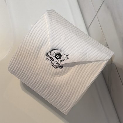 Toilet paper folded into a neat point with the Breeze Clean stamp, our finishing touch