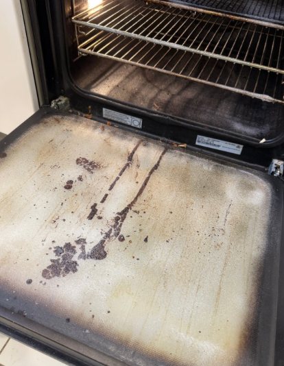 Before: Oven door glass covered in baked-on grease
